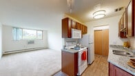 Located at 6904 10th St N in Oakdale, Minnesota, this one-bedroom, one-bathroom residence offers a practical and well-appointed single-floor layout. The galley-style kitchen is a standout feature, showcasing rich warm-toned wood cabinetry, granite countertops, wood-look flooring, and white appliances including a range, over-the-range microwave, and refrigerator. Ample upper and lower cabinet storage makes the kitchen both functional and visually appealing.

The combined living area flows naturally from the kitchen, featuring soft carpeted flooring, a ceiling fan, baseboard heating, and a window unit for climate control. A large window allows natural light to fill the space while offering views of the surrounding greenery. The bedroom continues the carpeted aesthetic, complete with a ceiling fan, a window with outdoor views, a baseboard heater, and a sliding-door closet for convenient storage.

The bathroom is clean and well-equipped, featuring a single-sink vanity with wood cabinetry, a large mirror, a tiled tub-shower combination, and tile flooring. Throughout the unit, the neutral color palette and consistent finishes create a cohesive, comfortable living environment suited for everyday functionality.