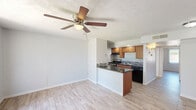 Located at 6320 N 16th St in Phoenix, AZ, this efficiently designed one-bedroom, one-bathroom unit offers a well-organized single-floor layout that maximizes every square foot. Light wood-look flooring runs throughout, creating a cohesive and clean aesthetic across all rooms.

The open-concept kitchen serves as a central hub of the unit, featuring warm wood cabinetry, dark granite-style countertops, a peninsula with additional counter space, a gas range, black refrigerator, and a white subway tile backsplash. The kitchen flows seamlessly into the living area, making the space feel open and connected.

The bedroom is a comfortable, well-lit room with painted brick walls, a ceiling fan with light fixture, and a window that allows natural light to filter in. Built-in storage solutions include a full-length mirror door, a closet, and a white built-in shelving and drawer unit, offering practical organization without sacrificing space.

The bathroom is a standout feature, showcasing a tub and shower combination with floor-to-ceiling large-format gray tile and decorative vertical mosaic tile accents in mixed tones of silver, gray, and brown. Chrome fixtures complete the polished look.

Textured ceilings are present throughout, adding a classic character consistent with the building's architectural style.