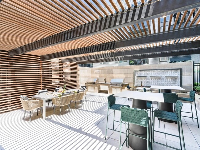 Gather under the slatted shade for casual cookouts or weekend brunches—perfect for connecting with neighbors or entertaining friends in style. - Modera Falls Church
