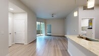 This 910-square-foot apartment at 2157 E Apache Blvd in Tempe, Arizona offers a single-floor layout with 2 bedrooms and 3 bathrooms. Light-toned wood-style flooring flows throughout the main living areas, complementing a neutral color palette that creates a clean, modern aesthetic throughout.

The open kitchen is a standout feature, equipped with stainless steel appliances including a gas range, microwave, refrigerator, and dishwasher. Two-tone cabinetry pairs white upper cabinets with warm wood-finish lower cabinets, accented by granite countertops and a peninsula with an undermount sink and pendant lighting above.

The living room connects seamlessly to the kitchen and opens to an outdoor patio via a sliding glass door, allowing natural light and exterior views. The bedrooms feature plush carpeting and access to natural light; the primary bedroom includes a walk-in closet and sliding mirror doors. Each bathroom features warm wood-tone vanities with white countertops and light wood-style flooring. One bathroom includes a full soaking tub with tile surround. A dedicated in-unit laundry room with washer and dryer adds practical convenience to this well-appointed apartment.