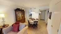This two-floor home offers a thoughtfully arranged layout designed for comfortable everyday living. The main level features a cozy living room with soft carpeting, neutral walls, and ample space for seating, creating an inviting atmosphere for relaxation and gathering. Adjacent to the living room, a dedicated dining area is anchored by a chandelier overhead and flows seamlessly into the kitchen, making it ideal for both casual meals and entertaining.

The kitchen is efficiently designed with white cabinetry, generous counter space, and a full suite of appliances including an electric range and dishwasher. A window above the sink allows for natural light to brighten the workspace.

The bedrooms are comfortably scaled and feature plush carpeting, ceiling fans with light fixtures, and natural light from well-placed windows. Each bedroom offers closet storage, and the overall palette of soft, neutral tones lends a calm and restful ambiance throughout. One bedroom includes a spacious walk-in style closet and direct access to the staircase landing.

The bathroom is cleanly finished with a tub-shower combination, vanity, and warm wall tones that complement the home's cohesive aesthetic. Throughout both floors, the design emphasizes practicality and comfort, making this a welcoming and functional home.