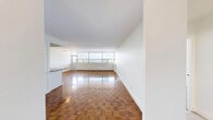 Located on the 9th floor at 12-24 Leith Hill Road in Toronto's North York neighbourhood, this one-bedroom, one-bathroom unit offers a well-organized layout with comfortable living space throughout. The open living room is a standout feature, boasting floor-to-ceiling windows along an entire wall that flood the room with natural light and frame breathtaking panoramic views of Toronto's skyline and the surrounding tree canopy. Gleaming parquet hardwood flooring runs throughout the living areas and bedroom, adding warmth and classic character to the space. The renovated kitchen is thoughtfully designed with white shaker-style cabinetry, dark countertops, a light blue glass tile backsplash, and a full suite of stainless steel appliances including a refrigerator, dishwasher, gas range, and built-in microwave. Light tile flooring completes the kitchen's clean, modern aesthetic. The bedroom is a comfortable retreat featuring a large window with scenic treetop and city views, parquet flooring, and mirrored sliding closet doors. The bathroom is finished with neutral tile, a full soaker tub with shower, and a vanity with ample storage. A private balcony accessible from the living area offers sweeping, unobstructed views of the Toronto skyline and lush greenery below.