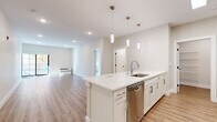Located at 305 Patterson St in Hillsdale, NJ, this thoughtfully designed 2-bedroom, 2-bathroom residence offers a clean, modern aesthetic throughout its well-proportioned single-floor layout. Light wood-tone flooring and a neutral color palette create a bright, cohesive atmosphere across every room.

The open-concept kitchen and living area serves as the heart of the home. The kitchen features a large waterfall-edge island with an undermount sink, white shaker cabinetry, a subway tile backsplash, and a full suite of stainless steel appliances including a gas range, over-range microwave, refrigerator, and dishwasher. Elegant pendant lighting illuminates the island. The spacious living area extends naturally from the kitchen and opens to an outdoor space via large black-framed sliding glass doors that invite generous natural light and views of surrounding foliage.

The generously sized primary bedroom offers a tranquil retreat with a window framing colorful seasonal tree views. The second bedroom is equally well-appointed with warm wood flooring and ample wall space. Both bathrooms are finished in crisp white, with one featuring a soaking tub and subway-tiled shower surround, a white vanity, and large-format tile flooring. A dedicated laundry area houses a stacked washer and dryer unit alongside wire shelving for additional storage.