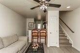 Located at 2625 Barn Valley Way in Knoxville, Tennessee, this two-floor home offers a thoughtfully designed layout with consistent, modern finishes throughout. Light-toned wood-style flooring flows seamlessly across the living spaces, complemented by neutral walls that create a bright and welcoming atmosphere.

The living area is generously sized, featuring large windows that allow ample natural light to fill the room. A ceiling fan with integrated lighting adds comfort, while the open sightlines connect the space to a raised breakfast bar — ideal for casual dining or entertaining.

The kitchen is well-appointed with white cabinetry, dark granite-style countertops, a stainless steel electric range, a double-basin sink, and a dishwasher. The layout is functional and efficient, with staircase access visible nearby, connecting the two floors.

The bedrooms are spacious and restful, each equipped with ceiling fans and windows providing natural light. Walk-in and standard closets offer practical storage, and the rooms comfortably accommodate full bedroom furnishings. The bathroom features wood-style flooring, a shower with curtain enclosure, and a window for ventilation and natural light.

Overall, the home presents a clean, move-in-ready environment with consistent design choices that balance practicality and comfort across both floors.
