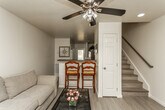 Located at 2625 Barn Valley Way in Knoxville, Tennessee, this two-floor home offers a thoughtfully designed layout with consistent, modern finishes throughout. Light-toned wood-style flooring flows seamlessly across the living spaces, complemented by neutral walls that create a bright and welcoming atmosphere.

The living area is generously sized, featuring large windows that allow ample natural light to fill the room. A ceiling fan with integrated lighting adds comfort, while the open sightlines connect the space to a raised breakfast bar — ideal for casual dining or entertaining.

The kitchen is well-appointed with white cabinetry, dark granite-style countertops, a stainless steel electric range, a double-basin sink, and a dishwasher. The layout is functional and efficient, with staircase access visible nearby, connecting the two floors.

The bedrooms are spacious and restful, each equipped with ceiling fans and windows providing natural light. Walk-in and standard closets offer practical storage, and the rooms comfortably accommodate full bedroom furnishings. The bathroom features wood-style flooring, a shower with curtain enclosure, and a window for ventilation and natural light.

Overall, the home presents a clean, move-in-ready environment with consistent design choices that balance practicality and comfort across both floors.