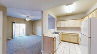 Located at 1260 E Guinevere St in Springfield, MO, this single-floor, one-bedroom, one-bathroom unit offers a practical and comfortable layout. The living room is a generously sized, carpeted space anchored by a ceiling fan with light fixture, neutral beige walls, and a sliding glass door that opens to an outdoor deck, bringing in natural light and providing easy outdoor access. Adjacent to the living area, a dedicated dining space connects seamlessly to the kitchen via a convenient pass-through window. The kitchen features light wood cabinetry, tile flooring, ample counter space, a double sink, dishwasher, refrigerator, and a skylight-style overhead fixture that brightens the room. A hallway connects the main living areas to the private bedroom, which is spacious and carpeted with a ceiling fan, a natural light window, and a closet with built-in rod storage. The bathroom includes tile flooring, a tub-shower combination with sliding glass doors, and clean, neutral finishes. Additional spaces include a utility room, laundry area, and two closets, ensuring practical storage throughout. The consistent neutral palette and carpet flooring unify the space for a cohesive, move-in-ready feel.