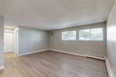Located in Lakewood, Colorado, this single-floor, two-bedroom, one-bathroom residence offers a functional and well-appointed layout. Throughout the home, light wood-style vinyl flooring creates a clean, cohesive look, complemented by neutral gray walls and white trim. The open living room is generously sized, featuring a textured ceiling, a wall-mounted air conditioning unit, baseboard heating, and multiple windows that bring in natural light and outdoor views. A ceiling fan adds to the comfort of the space. The galley-style kitchen is thoughtfully designed with white shaker cabinetry, light stone-look countertops, a white subway tile backsplash, and stainless steel appliances including a refrigerator, dishwasher, microwave, and electric range. A skylight overhead brightens the cooking space. The primary bedroom is a comfortable size with a double-door closet and direct access to the bathroom. The second bedroom also features a window with outdoor views and baseboard heating. The full bathroom is finished in white tile with a tub/shower combination and brushed nickel fixtures. A dedicated closet provides additional storage. This residence offers a practical and modern living environment in a well-connected Lakewood location.