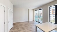 Located at 500 North Andrews Avenue in the heart of Fort Lauderdale, FL, this two-bedroom, one-bathroom residence offers a clean, modern aesthetic throughout its efficiently designed single-floor layout. Wood-look plank flooring runs continuously through the living areas and bedrooms, providing warmth and visual cohesion across the space.

The kitchen is a standout feature, outfitted with flat-front white cabinetry extending to the ceiling, a marble-style tile backsplash, stainless steel appliances including a refrigerator, range, microwave, and dishwasher, and a neutral countertop with an undermount sink. Track lighting overhead and large black-framed windows allow natural light to fill the space while offering urban views of the surrounding cityscape.

The living area opens directly onto a private balcony through sliding glass doors, framing sweeping views of the Fort Lauderdale skyline — a defining feature of this unit. Both bedrooms are finished with the same neutral palette and wood-look floors, offering flexible, light-filled spaces. The primary bedroom connects conveniently to the hallway layout.

The bathroom is appointed with a full soaking tub and shower combination, clad in large-format marble-style tile from floor to ceiling, complemented by brushed nickel fixtures and recessed lighting. The overall design is contemporary and understated, with a neutral color scheme that creates a bright, airy atmosphere throughout.
