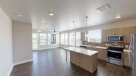 Located at 355 Eldorado Blvd in Broomfield, Colorado, this modern single-floor residence showcases a clean, contemporary design with an open-concept living and kitchen area at its core. Rich dark hardwood-style flooring runs throughout the main living spaces, contrasting beautifully with the light, neutral wall tones that define the interior palette.

The kitchen is a standout feature, outfitted with two-tone wood-grain cabinetry, crisp white quartz countertops, a tiled backsplash, and a full suite of stainless steel appliances including a refrigerator with ice maker, electric range, microwave, and dishwasher. A central island with pendant lighting adds both function and style, flowing seamlessly into the open living area. Multiple large windows and access to an outdoor balcony flood the living space with natural light and outdoor views, while a ceiling fan provides year-round comfort.

The bedrooms are carpeted and well-proportioned, each featuring ceiling fans, recessed lighting, and windows that bring in natural light. The bathrooms are finished with wood-grain vanity cabinetry, white quartz countertops, and a tub-shower combination with decorative tile accenting. The overall ambiance is bright, clean, and move-in ready, reflecting a thoughtfully designed modern living environment.