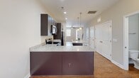 Located at 10154 Enniscrone Rd in Pineville, NC, this two-story home offers a well-organized layout spread across two floors. The main level encompasses the primary living areas, where an open-concept design connects the kitchen and living room seamlessly. The kitchen is equipped with stainless steel appliances, dark espresso cabinetry, granite countertops, and a peninsula with pendant lighting overhead — ideal for both cooking and casual dining. The living room features durable hardwood-style flooring, neutral warm-toned walls, a ceiling fan with light fixture, and a front entry door flanked by a sidelight window that draws in natural light.

The upper level houses both bedrooms and two full bathrooms. The generously sized primary bedroom offers a notably spacious layout with plush carpeting, multiple windows providing outdoor views and natural light, and a closet. The second bedroom is similarly appointed with carpet flooring and natural light. Both bathrooms are finished with granite-topped vanities, undermount sinks, white cabinetry, and brushed chrome hardware, delivering a clean, cohesive aesthetic throughout the home.