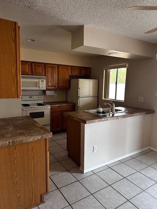 Kitchen area with appliances included (microwave, stove, refrigerator, dishwasher) - 4791 W Red Wolf Dr
