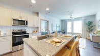 Located at 8855 McGallion Rd in Houston, TX, this 2-bedroom, 2-bathroom residence offers a thoughtfully designed single-floor layout that maximizes every square foot. The open-concept kitchen flows seamlessly into the living area, creating an inviting and functional space. The kitchen is outfitted with white shaker cabinets, granite countertops, a subway tile backsplash, stainless steel appliances — including a refrigerator, dishwasher, electric range, and microwave — and a peninsula with bar seating, ideal for casual dining. The living room is bright and airy, featuring large windows that flood the space with natural light, wood-style flooring, and a ceiling fan. Both bedrooms are comfortably sized, each offering large windows with outdoor views, wood-style flooring, and ceiling fans. The primary bedroom is served by a private en-suite bathroom with a glass-enclosed walk-in shower, granite vanity countertop, and wood-style flooring. The second bathroom features a granite vanity and a combination tub-shower. Neutral tones and clean lines carry throughout the residence, contributing to a cohesive, modern aesthetic. A dedicated closet provides additional storage, completing this practical and well-finished home.