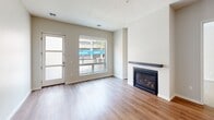 Located at 208 Second St SE in Minneapolis, MN, this well-appointed two-bedroom, four-bathroom residence offers a thoughtfully designed single-floor layout. The open-concept kitchen is a standout feature, showcasing white shaker cabinetry, granite countertops, a subway tile backsplash, a center island, and a full suite of stainless steel appliances including a gas range, dishwasher, microwave, and refrigerator. Warm hardwood-style flooring flows throughout the main living areas, complementing the bright and airy living room, which is anchored by a fireplace with a sleek dark wood mantel and large windows that bring in natural light. Both bedrooms are carpeted and offer a comfortable, quiet retreat, with the primary bedroom featuring its own dedicated bathroom complete with a granite-topped white vanity and wood-look flooring. Two closets provide organized storage space, each equipped with wire shelving systems. The four bathrooms are consistently finished with white cabinetry, granite countertops, and illuminated vanity mirrors. The overall aesthetic is clean and modern, with neutral tones creating a cohesive and inviting atmosphere throughout the space.