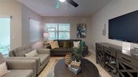 This two-story home offers a thoughtfully designed layout that balances functionality with comfortable living across multiple rooms. The kitchen serves as a central hub, showcasing warm medium-toned wood cabinetry paired with light granite countertops and tile flooring. Black appliances, recessed lighting, and a peninsula breakfast bar with barstool seating make it equally suited for casual dining and meal preparation. The kitchen opens directly to the living area, which features tile flooring, a ceiling fan, and abundant natural light through wide, slatted blinds. A sliding glass door connects the living space to a paved brick patio overlooking a lush green yard, offering a seamless indoor-outdoor experience. The bedrooms feature soft carpeting, ceiling fans, and natural light from well-positioned windows, with the primary bedroom accompanied by a walk-in closet and an en-suite bathroom featuring a glass-enclosed tile shower and granite vanity. A secondary full bathroom includes a tub-shower combination, granite countertops, and a window for natural ventilation. A dedicated laundry room with full-sized washer and dryer units adds everyday convenience to this well-rounded home.