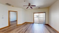 Located at 218 Wolfe St in Oregon, Wisconsin, this one-bedroom, one-bathroom unit offers a well-organized single-floor layout that makes efficient use of its comfortable living space. The open-concept kitchen and living area serve as the heart of the home, featuring warm honey-toned cabinetry, a peninsula with an integrated sink, and white appliances including a range, microwave, and refrigerator. Track lighting and a flush ceiling fixture illuminate the kitchen, while light hardwood-style flooring and warm wood trim flow consistently throughout the entire unit. The living room is bright and inviting, enhanced by a ceiling fan, an elegant chandelier, and sliding glass doors that open directly to a private balcony. The bedroom is a well-proportioned retreat with a ceiling fan, a window offering natural light, and access to a dedicated closet. The bathroom features a full-width vanity with warm wood cabinetry, a large mirror, a soaking tub with shower, and neutral tile flooring. Clean white walls and consistent warm wood accents throughout lend the space a cohesive, welcoming aesthetic well-suited for comfortable everyday living.