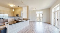 Located at 1104 Via Corso Ave in Mauldin, South Carolina, this well-appointed 3-bedroom, 2-bathroom residence offers a thoughtfully designed single-level layout with modern finishes throughout. Wood-look plank flooring flows seamlessly across the open-concept living and dining areas, which are bathed in natural light through multiple windows and a set of elegant French doors that open to a private balcony with outdoor views.

The kitchen is a standout feature, outfitted with light wood cabinetry, a subway tile backsplash, dark granite countertops, and stainless steel appliances including a refrigerator, range, and built-in microwave. A peninsula with a dark countertop and pendant lighting provides additional prep and seating space while maintaining an open connection to the living area.

The spacious primary bedroom connects directly to a walk-in closet equipped with wire shelving, which leads into the primary bathroom. This bathroom features a light wood vanity with granite countertops, a framed mirror, and tile flooring. The secondary bathroom mirrors the same refined design aesthetic with matching cabinetry and finishes. Additional bedrooms offer ample natural light via corner windows and ceiling fans, completing this clean, contemporary residence.