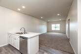Located at 4051 W Burlington Ave in Burlington, Iowa, this well-appointed one-bedroom, one-bathroom unit offers a thoughtfully designed single-floor layout. The open-concept kitchen and living area serves as the heart of the home, featuring light-toned luxury vinyl plank flooring, recessed lighting, and a seamless flow between cooking and living spaces. The kitchen is equipped with stainless steel appliances—including a refrigerator, electric range, and over-the-range microwave—complemented by crisp white shaker-style cabinetry and a peninsula island with a double-basin sink, ideal for both meal prep and casual dining. The spacious living area is bathed in natural light from a large window with outdoor views of the surrounding landscape. The generously sized bedroom continues the warm, neutral palette with plush carpeting and its own window offering natural light and outdoor views. A dedicated closet provides ample storage. The full bathroom features a clean, all-white tub and shower combination with chrome fixtures and wood-look vinyl flooring. A separate laundry area and a hallway complete the functional layout, making this a comfortable and efficiently organized living space.