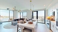 Located at 30 Peabody Street in Nashville, Tennessee, this well-appointed 2-bedroom, 2-bathroom residence offers a thoughtfully designed single-floor layout with a clean, contemporary aesthetic throughout. The entrance hallway sets an elegant tone, featuring light hardwood flooring, curated wall art, and a marble-topped console table framed by a gold-accented mirror — a refined introduction to the home.

The open-concept living, dining, and kitchen area serves as the heart of the space. Expansive floor-to-ceiling windows flood the room with natural light and frame sweeping views of the Nashville skyline, with direct access to a private balcony. The kitchen is outfitted with white shaker cabinetry, a subway tile backsplash, stainless steel appliances including a gas range, and a large waterfall-edge island with seating — ideal for both cooking and entertaining.

The primary bedroom benefits from a large picture window with panoramic city views, light hardwood floors, and generous closet space. Its en-suite bathroom features a dual-sink vanity with white cabinetry and a well-lit mirror. The second bedroom is equally bright and comfortable, served by a stylishly appointed full bathroom. Additional conveniences include a laundry area, utility room, and multiple closets throughout the home.