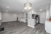 Located in the desirable Studio City neighborhood of Los Angeles, this well-appointed 2-bedroom, 2-bathroom single-story home offers a thoughtfully designed layout with modern finishes throughout. The open-concept living and kitchen area is bright and welcoming, featuring wood-look luxury flooring, recessed lighting, and elegant crown molding that adds a refined touch. A built-in white cabinetry unit in the living area provides both style and functional storage. Large windows with vertical blinds allow ample natural light to fill the space. The kitchen is efficiently designed with crisp white shaker cabinets, a tile backsplash, quartz countertops, and a full suite of stainless steel appliances, including a refrigerator, range, and dishwasher. Both bedrooms are carpeted and generously sized, each benefiting from natural light through wide windows. Three closets, including walk-in options, offer exceptional storage. The primary bathroom features a wide quartz vanity, large mirror, and a glass-enclosed shower. The second bathroom includes a shower-tub combo with a sliding glass door. A hallway connects the private quarters to the main living spaces, ensuring a practical and comfortable flow throughout the home.