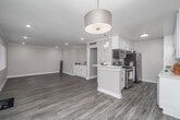 Located in the desirable Studio City neighborhood of Los Angeles, this well-appointed 2-bedroom, 2-bathroom single-story home offers a thoughtfully designed layout with modern finishes throughout. The open-concept living and kitchen area is bright and welcoming, featuring wood-look luxury flooring, recessed lighting, and elegant crown molding that adds a refined touch. A built-in white cabinetry unit in the living area provides both style and functional storage. Large windows with vertical blinds allow ample natural light to fill the space. The kitchen is efficiently designed with crisp white shaker cabinets, a tile backsplash, quartz countertops, and a full suite of stainless steel appliances, including a refrigerator, range, and dishwasher. Both bedrooms are carpeted and generously sized, each benefiting from natural light through wide windows. Three closets, including walk-in options, offer exceptional storage. The primary bathroom features a wide quartz vanity, large mirror, and a glass-enclosed shower. The second bathroom includes a shower-tub combo with a sliding glass door. A hallway connects the private quarters to the main living spaces, ensuring a practical and comfortable flow throughout the home.