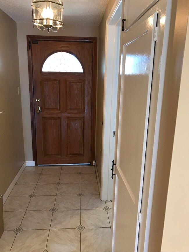 Entrada principal con suelo de baldosas y armario para abrigos. - 14911 Fonthill Ave