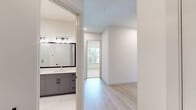 Located at 1345 14th St in Plano, Texas, this modern single-story home offers three bedrooms and two full bathrooms across a well-designed, open floor plan. The kitchen is a standout feature, showcasing a large quartz waterfall island with an undermount sink, two-tone cabinetry in white and slate gray, a subway tile backsplash, stainless steel appliances, and elegant glass pendant lighting. Light hardwood flooring flows through the kitchen and living areas, creating a warm, cohesive aesthetic. The living room receives generous natural light through large windows and a glass-panel door that opens to the outdoors. Each bedroom is thoughtfully designed — the primary bedroom features hardwood flooring and a ceiling fan, while the secondary bedrooms are finished with plush carpeting and bright windows offering pleasant outdoor views. Both bathrooms are appointed with large-format marble-look tile flooring and framed vanity mirrors. The primary bathroom includes a dual-sink vanity with slate gray cabinetry, white quartz countertops, and a soaking tub with matching marble tile surround. The second bathroom mirrors this refined style with a dual-sink vanity and a walk-in shower. A dedicated closet and clean, neutral walls throughout complete this polished, move-in-ready home.