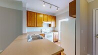 Located at 179 Emmaus Rd in Marysville, Ohio, this two-story home offers a well-organized layout with practical features spread across both levels. The kitchen is equipped with warm oak cabinetry, a peninsula with countertop overhang for seating, a stainless steel double sink, and white appliances including an electric range and refrigerator. Track lighting illuminates the workspace, and light hardwood-style flooring adds a clean, cohesive look throughout the kitchen area. The main living area is generously proportioned, with plush carpet, crown molding, and a sliding glass door that invites natural light and provides views of the surrounding greenery. A charming built-in shelving nook is tucked beneath the staircase, offering functional storage without sacrificing floor space. Upstairs, the bedrooms are carpeted and well-lit by multiple windows, creating bright and comfortable rooms. One area features a built-in desk, ideal for a home office or study space. The bathroom includes a long dual-sink vanity with oak cabinetry, a wide mirror, and hardwood-style flooring, providing ample counter space. Neutral wall tones and clean white trim are consistent throughout the home, lending a calm and cohesive aesthetic to every room.
