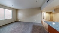 Located at 875 Cinnabar St in San Jose, California, this single-floor, three-bedroom, two-bathroom residence offers a practical and well-organized layout. The kitchen is equipped with light wood cabinetry, granite-style countertops, black appliances including a refrigerator, range, and dishwasher, and durable hardwood-style flooring. A peninsula counter connects the kitchen to the adjacent dining area, creating a natural flow into the living room, which features plush carpeting and access to a private balcony. The three bedrooms are carpeted and bathed in natural light through blinded windows, each offering ample wall space and closet storage — with four closets distributed throughout the unit. The primary bedroom is generously proportioned. Both bathrooms are finished with warm wood vanities, white countertops, large mirrors, and full tub-shower combinations. One bathroom features hardwood-style flooring, while the other is fitted with soft carpet. An in-unit laundry area adds everyday convenience. Throughout the residence, neutral tones and clean finishes create a calm, functional atmosphere well-suited for comfortable living in the heart of San Jose.