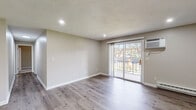 Located at 18 Brookside Ave in Worcester, MA, this single-floor residence has been thoughtfully updated with contemporary finishes throughout. The open living area is finished with light gray wood-look flooring and neutral-toned walls, creating a clean, versatile backdrop. Recessed lighting illuminates the space, while a wall-mounted HVAC unit and baseboard heating ensure year-round comfort. A sliding glass door leads to a private balcony with outdoor views, allowing natural light to flow into the living area. A hallway connects the main living space to the remainder of the unit.

The kitchen is well-appointed with white shaker cabinetry, granite countertops, a subway tile backsplash, a stainless steel sink, and a full suite of stainless steel appliances, including a refrigerator, range, microwave, and dishwasher. The bathroom features a granite-topped vanity with an undermount sink, a bathtub with shower, and consistent wood-look flooring.

The bedrooms are carpeted in soft gray and each receive natural light through windows with blinds, complemented by baseboard heating. The layout flows efficiently through a central hallway, providing a functional and cohesive living environment.