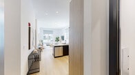 Located at 188 Broadway in Woodcliff Lake, NJ, this thoughtfully designed one-bedroom, one-bathroom residence offers a comfortable and modern living experience across a single floor. Light-toned hardwood flooring runs throughout, complementing the crisp white walls and creating a bright, cohesive aesthetic.

The open-concept kitchen and living area serves as the heart of the home. The kitchen features a two-toned design with dark lower cabinetry and light wood upper cabinets, a white quartz peninsula with seating, stainless steel appliances including a refrigerator, range, microwave, and dishwasher, and a clean white tile backsplash. The living area is bathed in natural light from large windows, providing an airy and welcoming atmosphere.

A dedicated den offers a quiet, private space ideal for a home office, complete with its own defined area separate from the main living spaces. The bedroom is a serene retreat with a large window, ample natural light, and a wall-mounted TV. The full bathroom is elegantly appointed with wood-grain vanity cabinetry, a white quartz countertop, matte black fixtures, a lighted mirror, and a glass-enclosed soaking tub and shower. Additional conveniences include an in-unit laundry area, a pantry, and a dedicated closet.