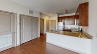 Located at 3115 Drewsky Ln in Fort Mill, SC, this single-floor residence offers a well-designed layout that balances functionality and comfort. The kitchen is a standout feature, showcasing rich dark-wood cabinetry that extends to the ceiling for ample storage, granite countertops, and a full suite of stainless steel appliances including a refrigerator, electric range, and built-in microwave. Warm hardwood flooring runs throughout the kitchen and adjoining areas, adding a polished, cohesive feel. A peninsula with a granite surface and an undermount sink serves as a natural divider between the kitchen and the living area, creating an open-concept flow that is ideal for both everyday living and entertaining. The living area is finished with soft, neutral carpeting and features a large window fitted with horizontal blinds, allowing for adjustable natural light and views of the surrounding neighborhood. The bathroom continues the design consistency of the unit, offering a wood-vanity with granite countertop, an undermount sink with chrome fixtures, a large mirror, and a shower-tub combination. Closet space is thoughtfully integrated throughout the unit, with double-door closets providing convenient storage. Clean, neutral wall tones throughout contribute to a bright and airy atmosphere.