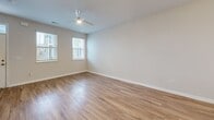 Located at 2909 Shoals Point Way in Leland, NC, this two-story, 2-bedroom, 3-bathroom home offers a well-designed layout spread evenly across two floors. The main level features a bright, open-concept living, dining, and kitchen area with warm hardwood-style flooring and a ceiling fan. The kitchen is a standout, boasting white shaker cabinetry, granite countertops, stainless steel appliances including a refrigerator, range, microwave, and dishwasher, and a central island with pendant lighting. A convenient in-unit laundry closet is tucked nearby. Three full bathrooms are finished with white vanity cabinetry, granite countertops, and hardwood-style flooring — one featuring a tub/shower combo with glass enclosure, another with a shower-curtain setup. The bedrooms offer plush carpeting, ceiling fans, and natural light from windows with blinds. The primary bedroom includes a tray ceiling detail and direct access to an en suite bathroom. The second bedroom features hardwood-style flooring and its own ceiling fan. Throughout, the home maintains a clean, neutral palette with bright white walls and modern finishes, creating a fresh and functional living environment.