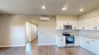 Located at 800 W Battles Rd in Santa Maria, California, this single-story 2-bedroom, 2-bathroom home offers a thoughtfully designed layout with modern finishes throughout. The open kitchen is a standout feature, equipped with stainless steel appliances including an electric range, over-the-range microwave, dishwasher, and refrigerator. Crisp white shaker-style cabinetry, light granite-look countertops, and wood-look vinyl plank flooring give the kitchen a clean, contemporary feel. A wall-mounted mini-split unit provides efficient climate control for the main living area, which is illuminated by recessed lighting. Both bedrooms are carpeted and filled with natural light from windows overlooking the surrounding neighborhood. The primary bedroom includes a walk-in closet, while additional bedrooms feature sliding-panel closets for ample storage. Three closets total are found throughout the home. The two bathrooms are finished with stone-look tile flooring and white vanities with granite-look countertops; one features a walk-in shower and the other a full tub-shower combo. A dedicated laundry area and a connecting hallway complete the functional floor plan, making this a practical and comfortable residence.