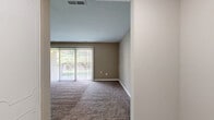 Located at 111 Versailles Cir in Towson, Maryland, this single-floor, 3-bedroom, 2-bathroom home offers a well-organized layout with a comfortable and functional design throughout. The space flows from a welcoming entrance through dedicated living and dining areas, both finished with plush carpeting and neutral warm-toned walls that create a cohesive, inviting atmosphere. The living area features large sliding glass doors dressed with vertical blinds, filling the space with natural light and providing direct views of the lush greenery outside. The dining area includes a pendant light fixture and its own sliding door access to the outdoors. The kitchen stands out with crisp white cabinetry, granite countertops, a subway tile backsplash, stainless steel appliances including a gas range and built-in microwave, hardwood-style flooring, and track lighting overhead. The spacious primary bedroom offers comfortable proportions with carpet flooring and a connected hallway. Two additional bedrooms are similarly carpeted with natural window light. Both bathrooms are finished with tile flooring, and one features a full tub-shower combo with white tile surround. Ample storage is available throughout via six closets, and the home also includes dedicated laundry and utility rooms.