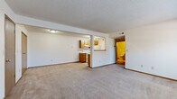 This single-floor, one-bedroom, one-bathroom unit offers a functional and efficient layout designed to make the most of its available space. The open-concept living and kitchen area forms the heart of the unit, with a spacious carpeted living room that provides ample room for comfortable furnishings. The kitchen is separated by a structural half-wall with a pass-through counter opening, creating a connected yet defined cooking space. It features warm oak-toned cabinetry, a white electric range, a stainless steel sink, and light-colored countertops, all set on durable tile flooring. A textured ceiling runs throughout the unit, adding a consistent design element. The hallway connects the main living area to the private bedroom and bathroom. The bedroom is a comfortably sized retreat, featuring plush carpeting, a large window that allows natural light to fill the room, and a double-door closet offering generous storage. The full bathroom includes a tub-shower combination, a toilet, a single-sink vanity with oak cabinetry, and tile flooring, offering a clean and functional design. White walls throughout the unit create a bright, neutral backdrop ready for personalization.