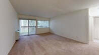 Located at 1420 Gregory St in Ypsilanti, MI, this one-bedroom, one-bathroom unit offers a comfortable and functional layout across a single floor. The living room is generously proportioned, featuring plush wall-to-wall carpeting, neutral-toned walls, and large sliding glass doors dressed with vertical blinds that fill the space with natural light and provide access to outdoor views. A wall-mounted HVAC unit and a ceiling fan ensure year-round comfort. The kitchen is efficiently designed and equipped with white appliances, including a range, along with ample cabinetry for storage. The spacious primary bedroom also features soft carpeting and includes access to a dedicated walk-in closet outfitted with built-in shelving and a hanging rod, offering generous storage capacity. The bathroom is clean and well-appointed, featuring a tiled tub-shower combination, a vanity with storage, a toilet, and classic mosaic tile flooring. A grab bar is also installed for added accessibility. Throughout the unit, the light, neutral color palette and consistent carpet flooring create a cohesive and welcoming ambiance, making this a practical and comfortable living space.