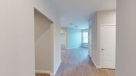 This thoughtfully designed two-bedroom, two-bathroom residence at 303 Lincoln Street in Marlborough, Massachusetts offers a clean, modern aesthetic throughout its well-utilized single-floor layout. Light-toned wood-look flooring flows consistently across the living areas and bedrooms, complemented by neutral gray walls and crisp white trim and doors that lend the space a bright, cohesive feel.

The kitchen is a standout feature, showcasing flat-front white cabinetry extending to the ceiling for ample storage, light quartz countertops, a subway-tile backsplash in soft gray tones, and a full suite of stainless steel appliances including a range, microwave, dishwasher, and refrigerator.

The spacious primary bedroom provides a comfortable retreat with natural light from a window and access to two closets, including a generously sized walk-in closet outfitted with multi-tiered wire shelving for organized storage. The second bedroom is well-proportioned with its own window providing natural light.

Both bathrooms are finished in a clean, contemporary style. The primary bathroom features a glass-enclosed walk-in shower and a warm wood-toned vanity, while the second bathroom includes a full soaking tub and shower combination. Two hallways connect the rooms efficiently, and the overall layout promotes easy flow throughout the residence.