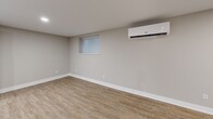 Located at 204 E Chester Pike in Ridley Park, PA, this thoughtfully designed one-bedroom, two-bathroom unit offers a clean, modern aesthetic with quality finishes throughout. The open-concept kitchen and living area serves as the heart of the space, featuring soft gray shaker-style cabinetry, a white quartz waterfall island, stainless steel appliances including a refrigerator, range, microwave, and dishwasher, and a white subway tile backsplash. Warm-toned luxury vinyl plank flooring runs throughout, complementing the neutral gray walls and crisp white trim. Recessed lighting illuminates the kitchen and living area, while a wall-mounted mini-split system ensures year-round climate comfort. The spacious primary bedroom includes a dedicated closet, a wall-mounted mini-split unit, and a window with blinds that brings in natural light. Two well-appointed bathrooms complete the unit — one featuring a backlit vanity mirror, single-sink vanity, and a glass-enclosed marble-tiled shower, and the other offering a similar refined design. Clean lines, a neutral color palette, and modern hardware unify the space, creating a cohesive and contemporary living environment.