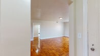 Located at 6900 Park Heights Ave in Baltimore, MD, this single-floor unit offers a well-organized layout with a clean, functional design throughout. One of the most distinctive features is the richly finished parquet hardwood flooring that runs through the main living areas and bedrooms, lending warmth and classic character to the space. The angled ceilings in portions of the unit add architectural interest, contributing to an open, airy feel.

The living area is generously sized, with neutral walls and natural light filtering through multiple windows. The bedrooms continue the parquet flooring and include closet space and individual windows that bring in outside views and daylight.

The kitchen is well-equipped, featuring light wood cabinetry, granite-style laminate countertops, a stainless steel single-basin sink, a black gas range, and a dishwasher. A window above the cooking area provides natural light and ventilation. A fire extinguisher is conveniently mounted nearby.

The primary bathroom features classic black-and-white tiling with a combination tub and shower, a wood-toned vanity, and a window for natural light. A secondary half-bath includes a matching vanity with a mirror and ample lighting, finished with neutral tile flooring and dark accent trim.