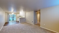 This single-story home offers a practical and well-organized layout across four bedrooms, two full bathrooms, two hallways, and a dedicated walk-in closet. The open-concept living and dining area flows seamlessly into the kitchen, which features white cabinetry, a peninsula counter, and white appliances. A sliding glass door in the living area fills the space with natural light and provides direct access to the outdoors. Neutral-toned carpet covers the living areas and bedrooms, while the kitchen and dining zone transition to hardwood-style flooring.

The bedrooms are carpeted and feature neutral wall tones, with several rooms benefiting from windows fitted with white blinds that allow for natural light and outdoor views. The primary bedroom includes access to a spacious walk-in closet outfitted with extensive wire shelving units on both sides, offering generous storage capacity.

Both bathrooms are finished consistently, each featuring a tub-shower combination, a vanity with a speckled countertop, white cabinetry, a wall mirror, and wood-look flooring. The clean, bright aesthetic maintained throughout both bathrooms adds a functional yet polished feel to the home. Two hallways connect the various rooms efficiently, contributing to the home's straightforward and accessible floor plan.