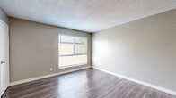 Located at 1104 Palm Avenue in National City, CA, this one-bedroom, one-bathroom unit offers a practical and well-appointed single-floor layout. The open living and dining area is finished with durable wood-look flooring and neutral warm-toned walls, creating a clean and inviting atmosphere. A ceiling fan provides added comfort, and multiple windows allow natural light to fill the space. The living area connects to an entry with two doors — one leading outside and one to a closet — offering convenient storage and access.

The galley-style kitchen is efficiently designed with white cabinetry lining both sides, light stone-finish countertops, a single-basin sink, and stainless steel appliances including a refrigerator and electric range. The wood-look flooring continues seamlessly into the kitchen, maintaining a cohesive aesthetic throughout.

The bedroom is comfortably sized, featuring plush carpeting, neutral gray-toned walls, and a window that brings in natural light and outdoor views. A textured ceiling is consistent throughout the unit, adding subtle visual character. The layout is functional and straightforward, making efficient use of the available space. This unit is well-suited for an individual or couple seeking a low-maintenance residence in National City.