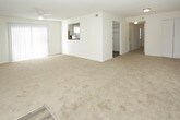 This single-story, 2-bedroom, 2-bathroom unit offers a practical and comfortable layout designed to maximize livability. The living area is carpeted and bathed in natural light through multiple windows fitted with blinds, complemented by a ceiling fan overhead and a textured ceiling throughout. A sliding glass door with vertical blinds provides additional light and access to the outdoors.

The kitchen features white cabinetry, light stone-style countertops, a tile backsplash, and a double-basin sink positioned beneath a window. Dark wood-style flooring ties the space together, and stainless steel appliances, including a refrigerator and dishwasher, add a modern touch alongside a black range.

Both bedrooms are generously sized, carpeted, and equipped with ceiling fans and windows that bring in natural light. One bedroom includes a built-in closet with bifold doors and shelving for convenient storage.

The two bathrooms each feature wood-style flooring and a tub/shower combination. One bathroom includes a window for natural ventilation, while both maintain a clean, bright aesthetic with white fixtures and chrome hardware throughout.