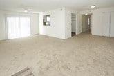 This single-story, 2-bedroom, 2-bathroom unit offers a practical and comfortable layout designed to maximize livability. The living area is carpeted and bathed in natural light through multiple windows fitted with blinds, complemented by a ceiling fan overhead and a textured ceiling throughout. A sliding glass door with vertical blinds provides additional light and access to the outdoors.

The kitchen features white cabinetry, light stone-style countertops, a tile backsplash, and a double-basin sink positioned beneath a window. Dark wood-style flooring ties the space together, and stainless steel appliances, including a refrigerator and dishwasher, add a modern touch alongside a black range.

Both bedrooms are generously sized, carpeted, and equipped with ceiling fans and windows that bring in natural light. One bedroom includes a built-in closet with bifold doors and shelving for convenient storage.

The two bathrooms each feature wood-style flooring and a tub/shower combination. One bathroom includes a window for natural ventilation, while both maintain a clean, bright aesthetic with white fixtures and chrome hardware throughout.