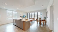 Located at 310 Del Sol Dr in San Diego's Mission Valley neighborhood, this contemporary single-floor residence showcases a thoughtfully designed open-concept layout with clean lines and modern finishes throughout. Polished concrete floors flow seamlessly across the main living areas, lending an urban, sophisticated character to the space.

The kitchen is a standout feature, equipped with stainless steel appliances, a gas range, a mosaic tile backsplash, and flat-front cabinetry in warm wood and muted gray tones. A generously sized island with a quartz countertop and an undermount sink offers both additional prep space and casual seating. The adjoining living and dining areas are bathed in natural light through floor-to-ceiling windows and sliding glass panels that frame views of palm trees and the surrounding San Diego landscape.

The bedrooms are bright and well-appointed, each featuring large windows with outdoor views. One bedroom is highlighted by a bold teal arched accent wall, while another features an artistic gold-toned wall mural, adding personality to the space. The bathrooms are finished with backlit vanity mirrors, quartz countertops, and contemporary cabinetry — one featuring a dual-sink vanity for added convenience. The overall ambiance of the residence is modern, airy, and vibrant.
