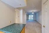 Located at 10717 Hillwood Dr in Silver Spring, MD, this single-floor, 4-bedroom, 2-bathroom home offers a functional and comfortable layout. The open-plan combined living and dining area is bright and welcoming, anchored by a pendant light fixture and carpeted flooring. A sliding glass door floods the space with natural light and provides outdoor access. The kitchen is well-appointed with warm oak cabinetry, green-toned countertops, a dishwasher, electric range, and built-in microwave, complemented by hardwood-style flooring and a window above the sink. The four bedrooms are carpeted and bathed in natural light from large windows with outdoor views of surrounding greenery. Each bedroom benefits from generous closet space, with the primary bedroom featuring dual closets. Both bathrooms are finished with oak vanities, white countertops, tub-shower combinations with white tile surrounds, and hardwood-style flooring. An in-unit laundry area adds everyday convenience. With eight closets distributed throughout, storage is plentiful. Multiple hallways connect the rooms efficiently, and the entrance provides a smooth transition into the home's interior.