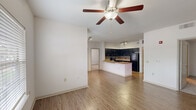 This single-story unit in Lake Charles, Louisiana offers a thoughtfully designed open-concept layout that maximizes its comfortable footprint. The living room serves as the central gathering space, featuring warm wood-style laminate flooring, a ceiling fan with light kit, textured ceilings, and multiple windows fitted with blinds that allow ample natural light to fill the room. A private entry door adds convenience and accessibility.

The kitchen is a standout feature, boasting dark espresso cabinetry, granite countertops, a subway tile backsplash, and black appliances including a refrigerator, range, and microwave. A peninsula with an undermount sink and additional counter space connects the kitchen seamlessly to the living area, making it ideal for everyday use and entertaining.

Both bedrooms are carpeted for comfort, each equipped with a ceiling fan and generous closet space. The primary bedroom includes a walk-in closet. The two bathrooms mirror the kitchen's design aesthetic, featuring granite-topped dark vanities, undermount sinks, wood-style flooring, and tub-shower combinations. Each bathroom is finished with large mirrors and well-placed lighting, contributing to a clean, cohesive look throughout the unit.