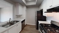 Located at 9100 Duarte Rd in San Gabriel, California, this single-floor unit offers a well-organized layout designed for comfortable everyday living. The open living and dining area is anchored by a classic fireplace and flows seamlessly across warm wood-look flooring, creating an inviting atmosphere throughout the main living space. A pass-through counter connects the living area to the kitchen, enhancing the sense of openness. The kitchen is efficiently designed with white cabinetry, light countertops, a stainless steel sink, dishwasher, gas range, and a full-size refrigerator, complemented by a skylight-style ceiling detail that brings in additional light. Two bedrooms are carpeted for comfort, each equipped with ceiling fans and closet space. The primary bedroom features a walk-in closet and direct access to other areas of the unit, while a secondary bedroom benefits from a large window with exterior views, filling the room with natural light. The full bathroom includes a combined tub and shower, a single vanity with a countertop sink, and wood-look flooring. Neutral wall tones and textured ceilings are consistent throughout, giving the unit a cohesive and understated aesthetic well-suited to a variety of furnishing styles.