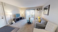 Located at 468 Gregory Ave in Glendale Heights, Illinois, this single-floor residential unit offers a well-organized layout with distinct living, sleeping, kitchen, and bathroom areas. The living room serves as the centerpiece of the unit, featuring plush carpeting, a wall-mounted air conditioning unit, and large sliding glass doors with vertical blinds that open to an outdoor patio, filling the space with natural light and views of the surrounding greenery. The room flows seamlessly into a dining area, creating an open and connected feel throughout. The galley-style kitchen is efficiently designed with dark espresso cabinetry, white countertops, a classic subway tile backsplash, wood-look flooring, and black appliances including a gas range and full-size refrigerator. The bedroom is a comfortable and bright retreat, finished with soft carpeting and a window overlooking lush outdoor greenery, allowing ample natural light. The full bathroom features white subway tile surrounding a soaking tub and shower combination, wood-look flooring, and a dark-stained vanity with a white countertop. Throughout the unit, neutral wall tones and consistent finishes provide a cohesive and welcoming atmosphere.