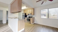 The Natoma 2-bedroom, 1-bathroom unit offers a well-organized single-floor layout designed for comfortable everyday living. The open-concept kitchen and living area serves as the heart of the home, featuring light wood cabinetry, stainless steel appliances including a refrigerator and electric range, and a kitchen peninsula that defines the space. Light wood-style flooring flows continuously throughout the unit, creating a cohesive and clean aesthetic. A ceiling fan in the living area adds both function and comfort, while a window brings in natural light and outdoor views.

Both bedrooms are bright and simply appointed, with the same light wood-style flooring, white walls, and windows that allow natural light to filter in. The primary bedroom offers a comfortable footprint, while the second bedroom provides a versatile space suitable for a variety of uses. A dedicated closet adds practical storage to the layout.

The bathroom is neatly arranged with a light wood vanity, countertop sink, toilet, and a full bathtub with shower. The light flooring and white walls keep the space feeling fresh and functional. Overall, the unit presents a clean, neutral palette throughout, making it an adaptable and move-in ready space.