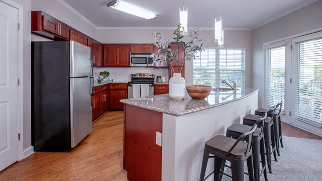 Entertain in style with our two-bedroom kitchens, boasting cherry wood cabinets and luxurious granite countertops for the perfect ambiance. - Rowan Park